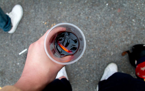 Low section of person holding drink on street