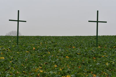 Cross on field against clear sky