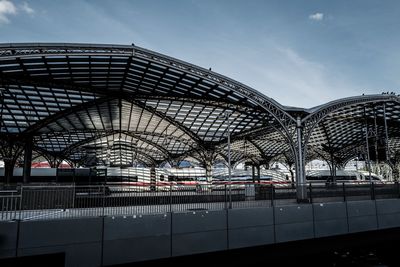 Train at railroad station in city against sky