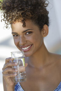 Portrait of a smiling young man drinking glass