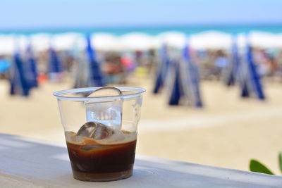 Close-up of drink on table at beach