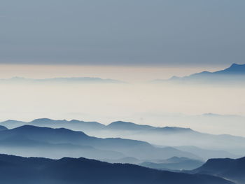 Scenic view of mountains against sky with fog