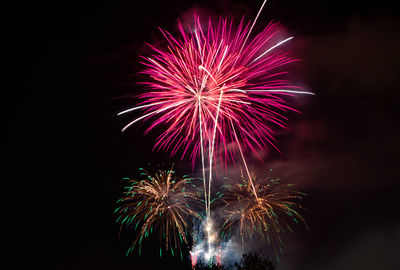 Low angle view of firework display at night