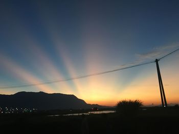 Scenic view of silhouette mountains against sky at sunset