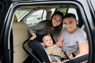 Portrait of happy family sitting in car