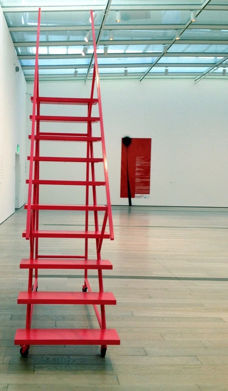 red, absence, empty, chair, built structure, striped, architecture, no people, indoors, day, seat, sunlight, railing, flag, wood - material, table, steps, shadow, wall - building feature, wall