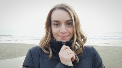 Portrait of young woman against clear sky