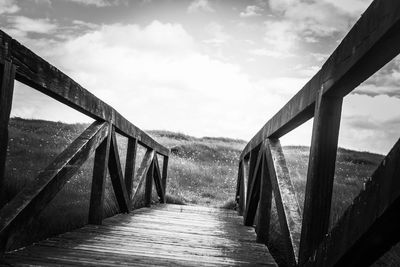 Footbridge over footpath against sky