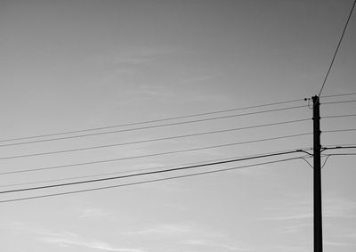 Low angle view of silhouette electricity pylon against sky