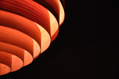 Close-up of illuminated lamp shade against black background