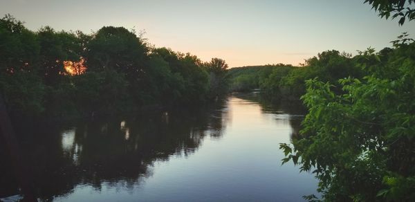 Scenic view of river against sky at sunset