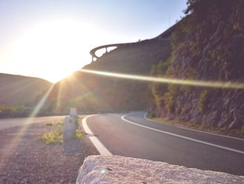 Road amidst landscape against clear sky during sunset