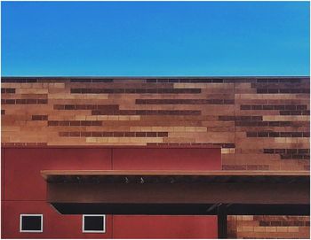 Brick wall against clear blue sky