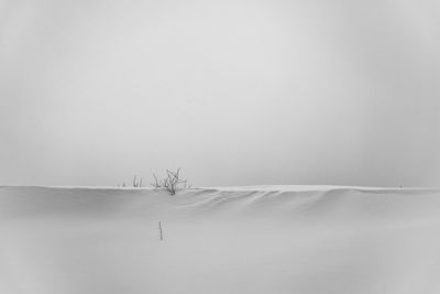 Scenic view of snow covered land against sky