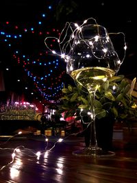 Illuminated christmas lights on glass table at night