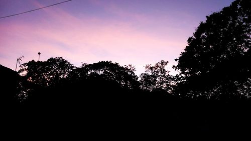 Low angle view of silhouette trees against sky at sunset