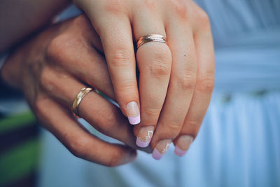 Cropped hands of husband and wife showing rings