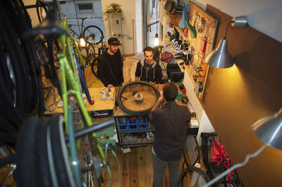 High angle view of customers talking to mechanic at workshop