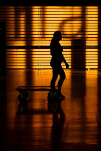 Side view of silhouette man walking on floor