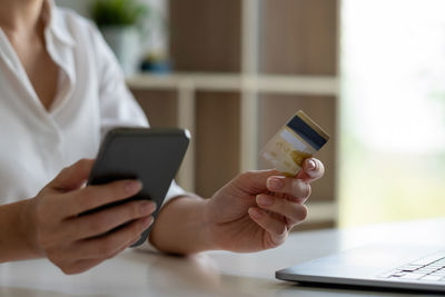 Midsection of man using mobile phone