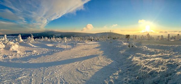 Panoramic view of snow covered landscape against sky