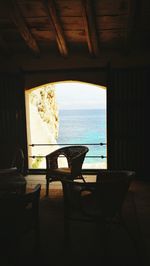 Chairs and table on beach by window