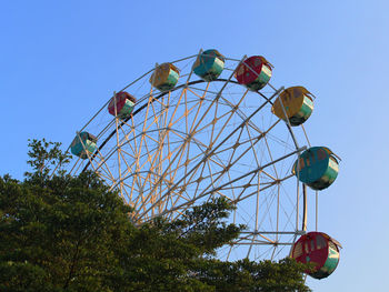 Low angle view of ferris wheel against clear blue sky