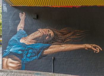 Midsection of man relaxing on wall