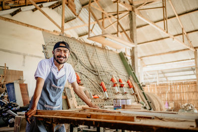 Portrait of young man standing in factory