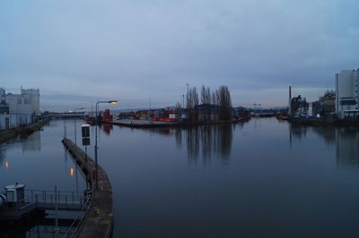 Scenic view of river by city against sky