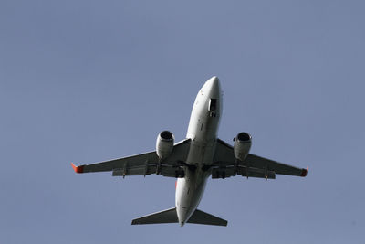 Low angle view of airplane flying against clear sky