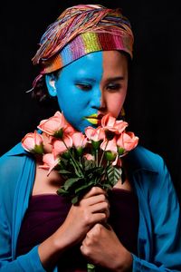 Portrait of woman holding red flower