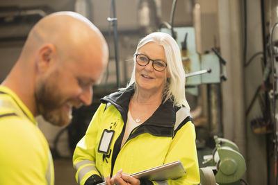 Male and female colleagues talking at work in workshop