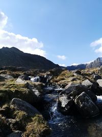 Scenic view of river and mountains against sky