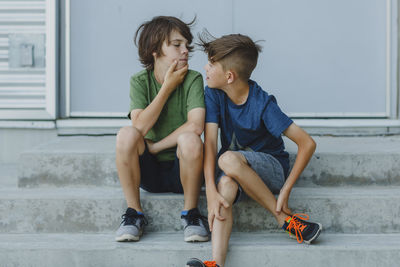 Brothers looking each other face to face outdoors