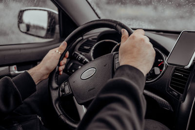 Midsection of man holding camera in car