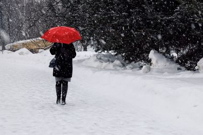 Woman with umbrella walking on snow