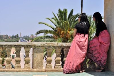 Woman standing with palm tree