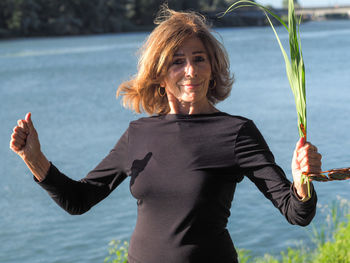 Young woman with arms outstretched standing in water