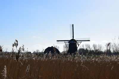 Traditional windmill on field against clear sky