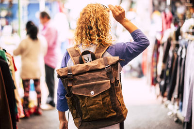 Rear view of woman with backpack walking in market