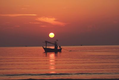 Silhouette boat in sea against sky during sunset