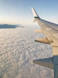 Airplane wing over cloudscape