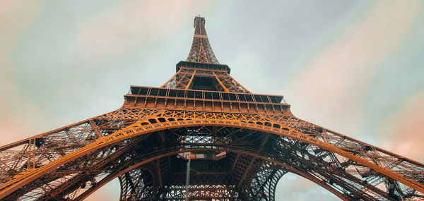 Low angle view of eiffel tower against cloudy sky