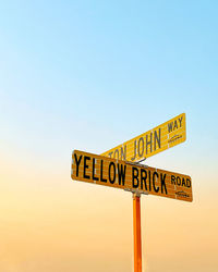 Low angle view of road sign against clear sky