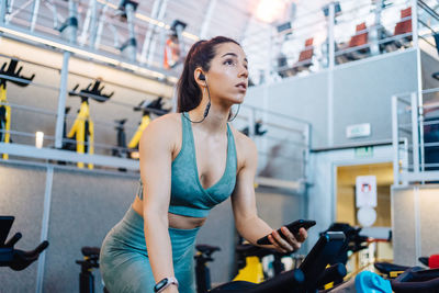 Young athlete on cardio bike in modern gym