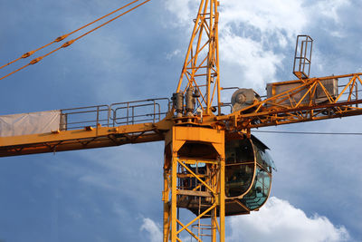 Low angle view of crane against sky