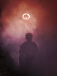 Silhouette man standing amidst smoke at barbecue