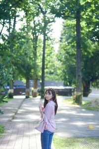 Portrait of young woman standing in park