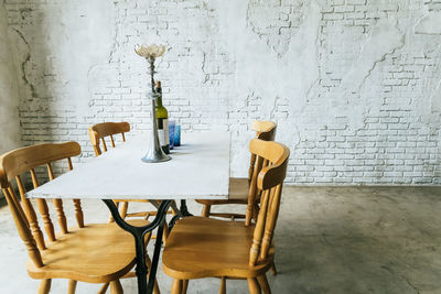 Empty chairs and tables against wall